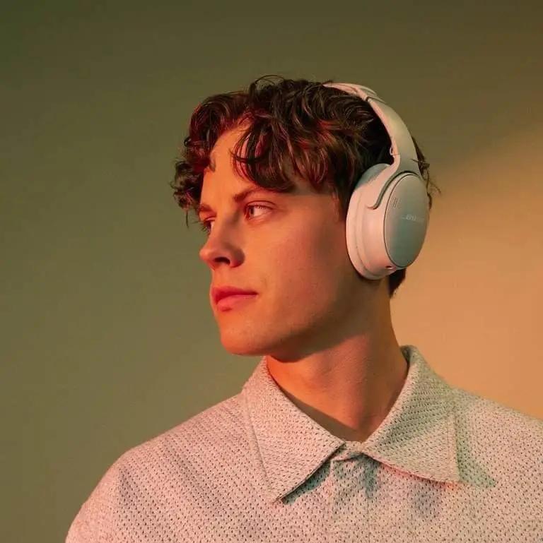 A picture of a man listening to music on his Bose wireless headphones.